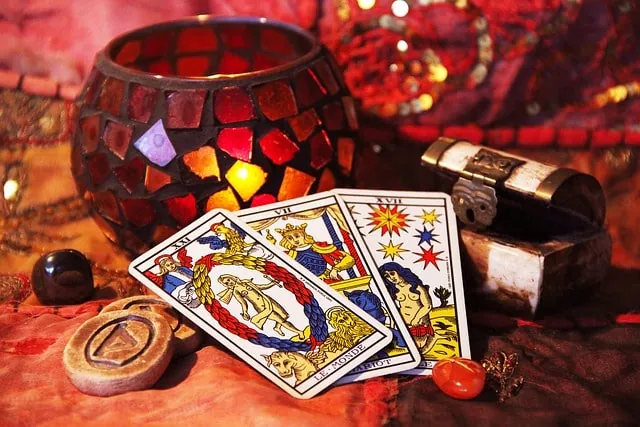 Cartas del tarot junto a un portavelas de mosaico encendido