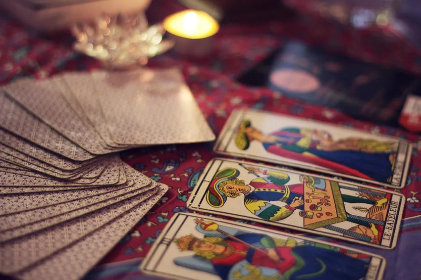 Mazo y cartas de Marsella sobre un mantel estampado